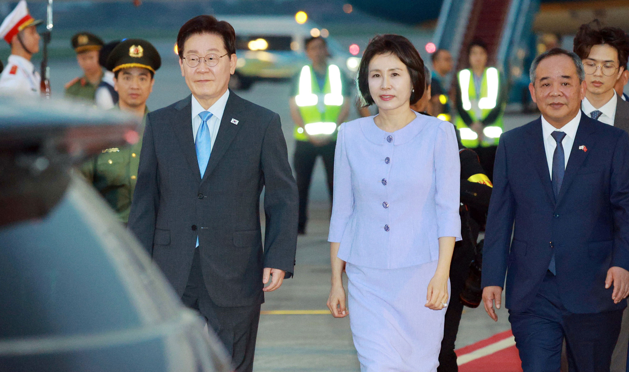 \"ベトナムを国賓訪問したイ・ジェミョン大統領とキム・ヘギョン夫人が21日（現地時間）、ハノイ・ノイバイ国際空港に到着した空軍1号機から降りて移動している。［聯合］\"