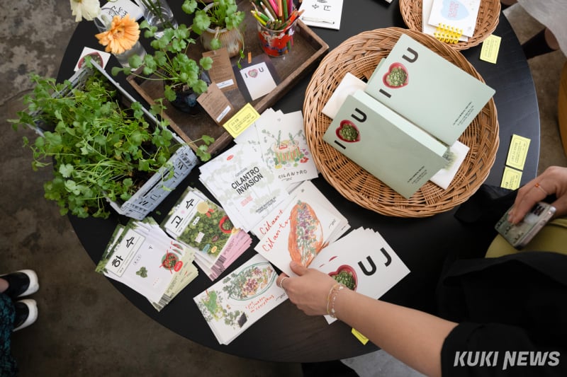 25日、ソウル北加佐洞のカフェで開かれた「コス ポップアップストア」で来場者が関連グッズを見ている。