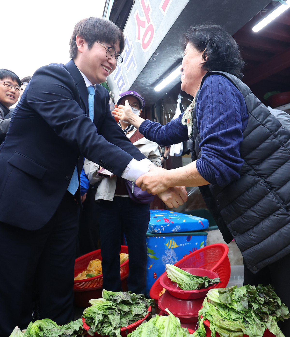 釜山北甲補欠選挙で共に民主党候補として出馬するハ・ジョンウ前青瓦台AI首席が29日午後、釜山北区クポ市場を訪れ、商人らとあいさつしている。聯合ニュース