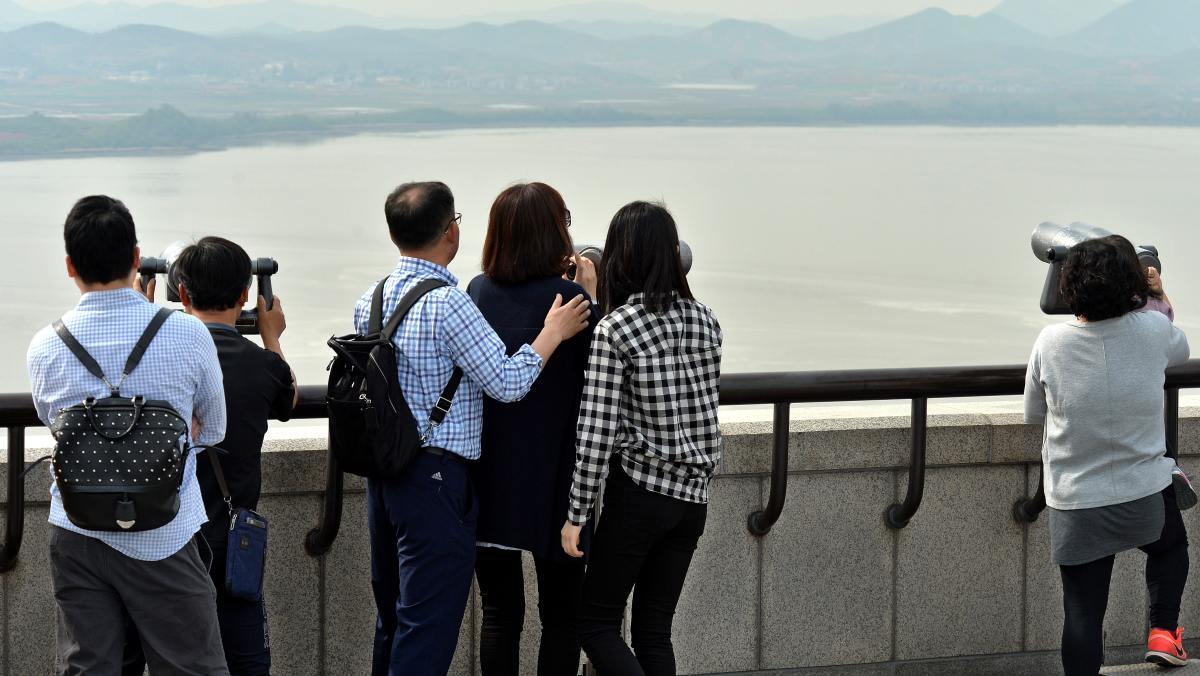 望遠鏡で北朝鮮を眺める市民