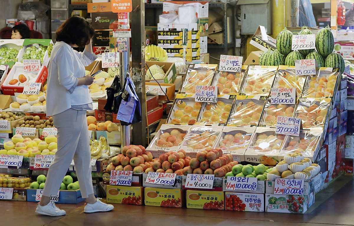市場で果物を眺める市民の様子（イメージ）