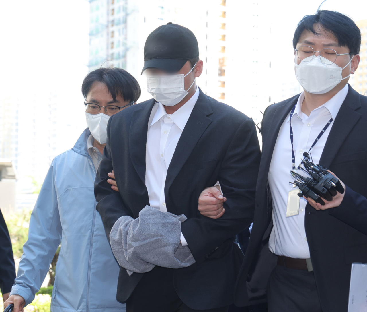 \"4日午前、京畿道・南楊州市の義政府地方法院南楊州支院で、故キム・チャンミン映画監督の傷害致死事件の被疑者（中央）が勾留前の被疑者尋問（令状実質審査）のため法廷へ移動している。