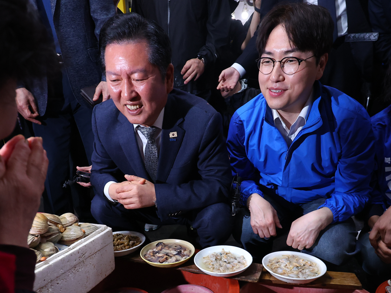 共に民主党のチョン・チョンレ代表と、北区甲の国会議員補欠選挙への出馬を正式表明したハ・ジョンウ前青瓦台AI未来企画首席が3日に釜山北区クポ市場で商人たちと会話している。［聯合］