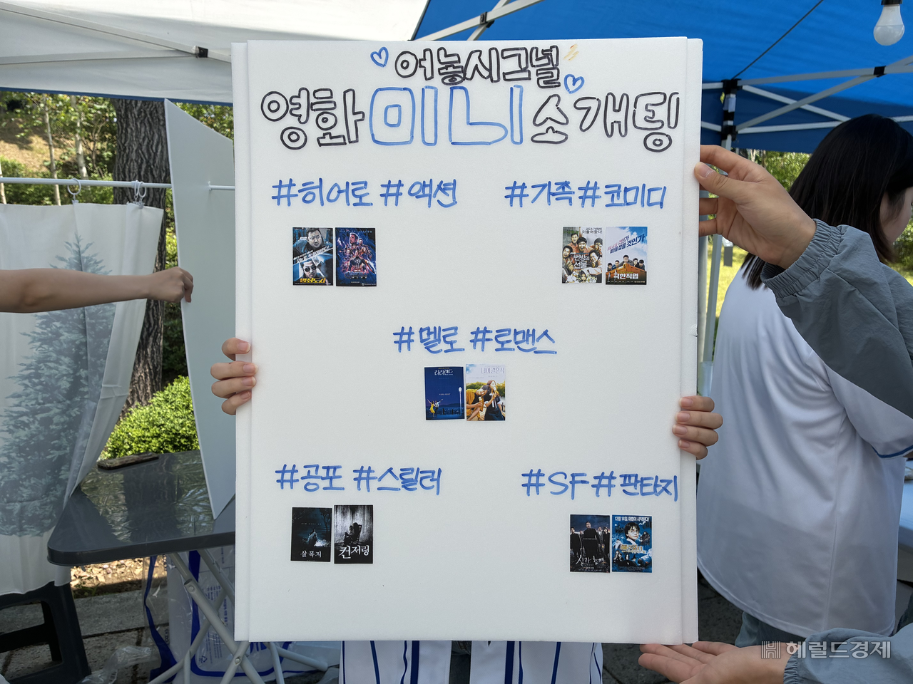 \"延世大学のメディア広報映像学部が企画した「어농시그널」ブースの広報物。学生たちは複数の映画ジャンルから好みを選び、一緒に映画を観ながら紹介される。キム・ソヒョン