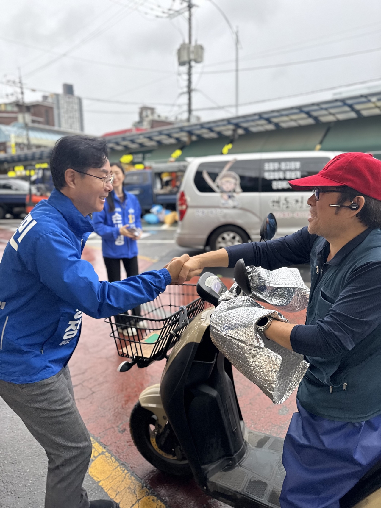 6・3地方選の公式選挙運動初日の21日午前、チェ・ドンミン（左）共に民主党・ソウル東大門区長候補が東大門区・제기동の京東市場を訪れ、商人と挨拶を交わしながら選挙運動をしている。【チェ・ドンミン候補キャンプ提供】