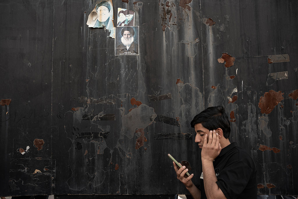 \"イランの若者が携帯の電波をつかもうとする様子。［ゲッティイメージ］\"