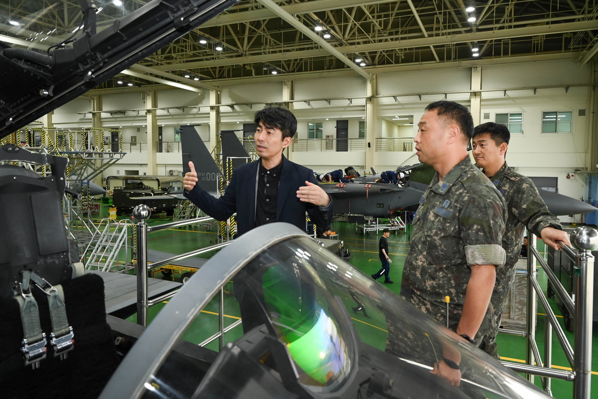 \"7日、大邱にある空軍第11戦闘飛行団でソウル経済新聞の記者イ・ヒョンホがF-15Kの操縦席前で操縦と整備に関する説明を受けている。写真提供=空軍\"
