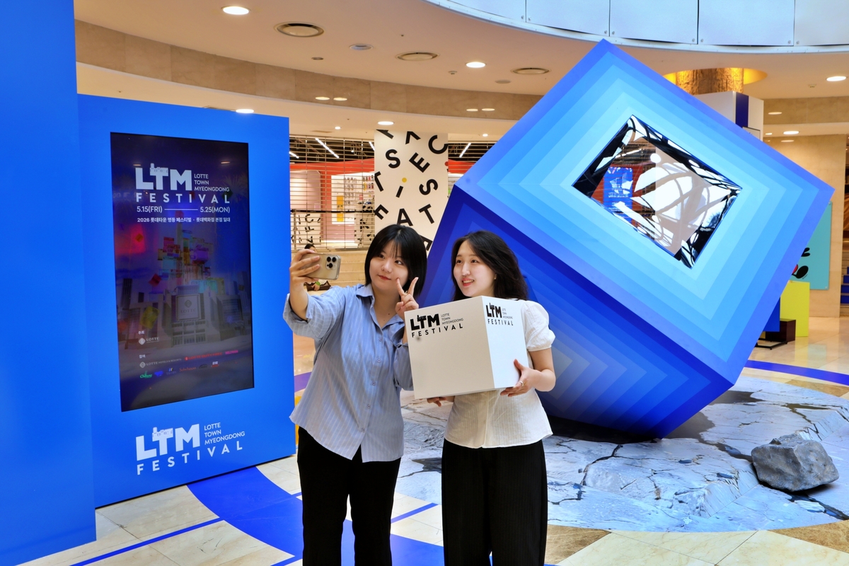 ソウル市小公洞に位置するロッテ百貨店本店地下1階のコスモエナジー広場に設置されたロッテタウンキューブフォトゾーンで記念撮影をする客の様子。写真提供=ロッテ百貨店