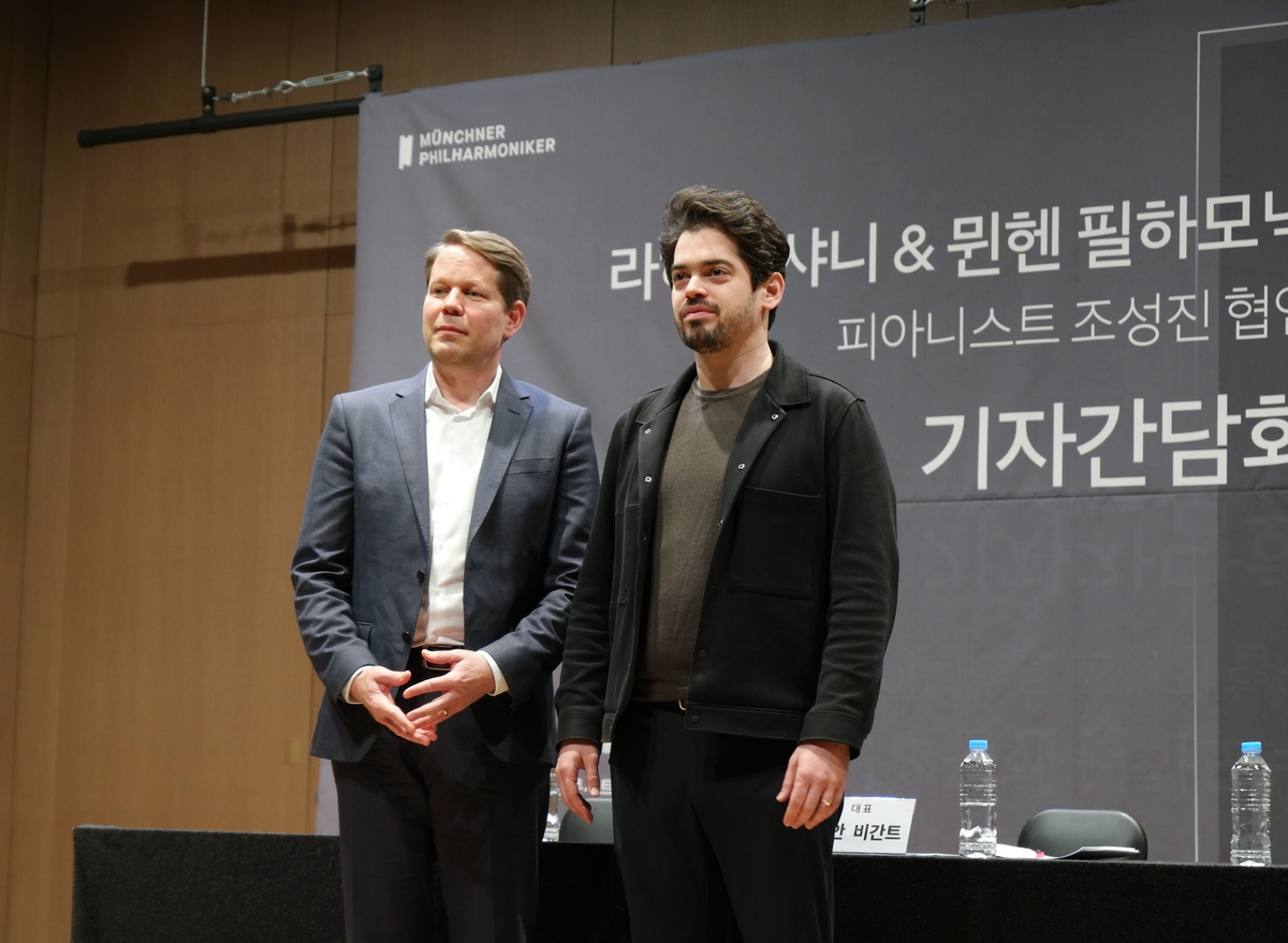 \"ミュンヘン・フィルハーモニー管弦楽団のフローリアン・ビガント（左）代表とラハブ・シャニ指揮者