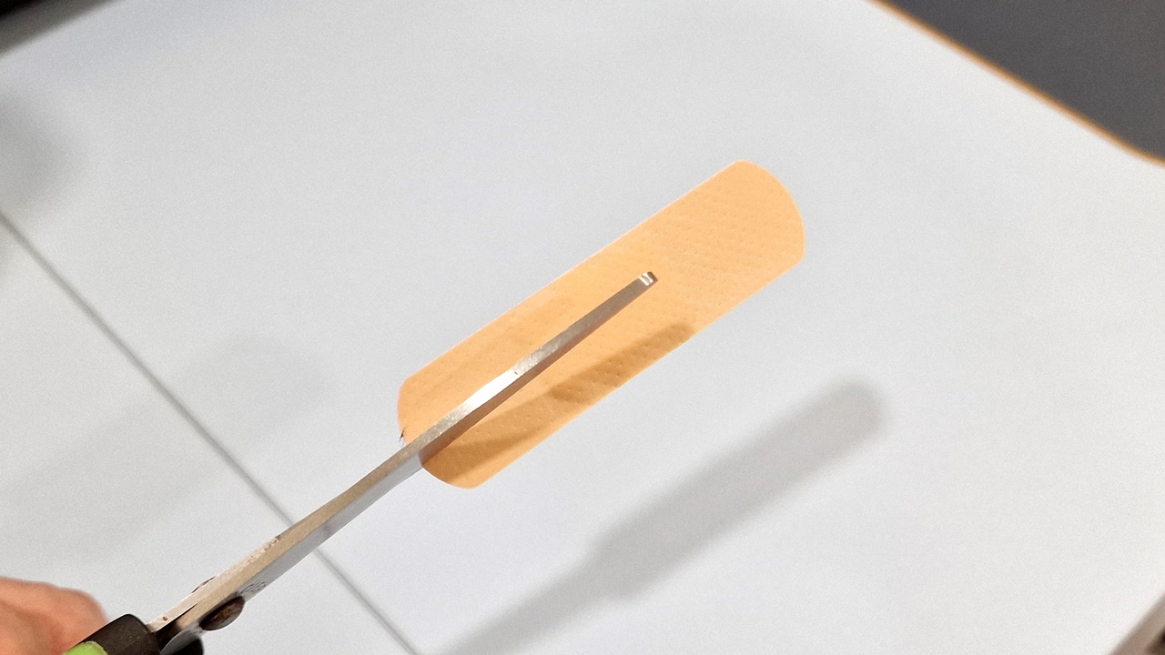 \"ハサミで切る前の絆創膏の写真\"