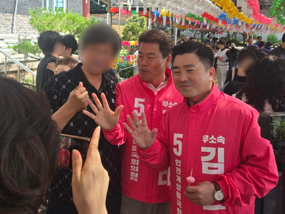 住民と記念写真を撮るキム・ヒョンテ候補の写真