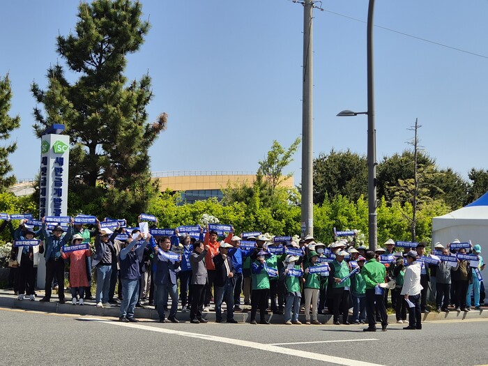 \"セマングムRE100国家産業団地ブアン誘致全郡民推進委員会とブアンの住民たちがグンサンのセマングム開発庁前でテント座り込み出陣集会を開き、RE100国家産業団地のブアン配置を求めるスローガンを叫んでいる。（写真＝ブアン住民推進委員会）\"