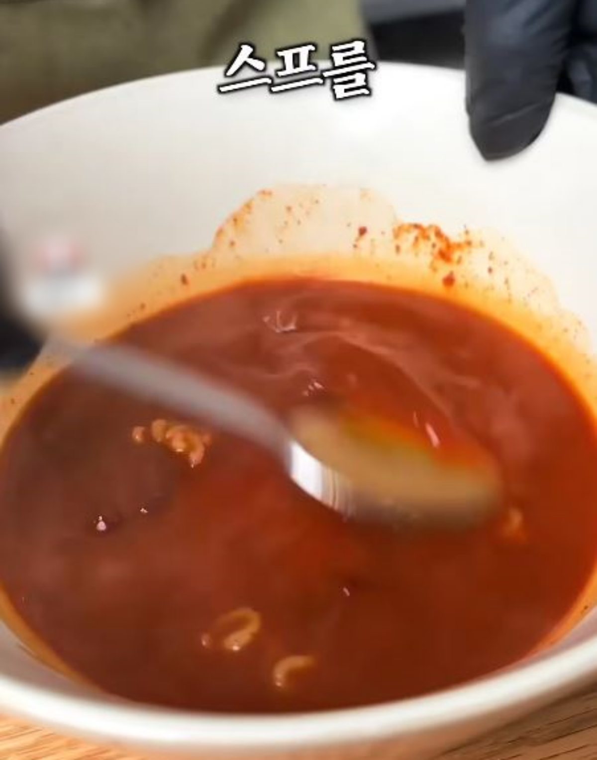 \"スープに麺のゆで汁を入れて溶かしている様子。\"