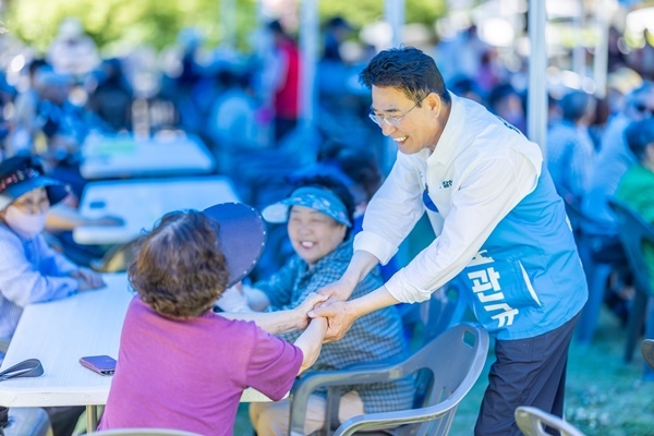 \"ノ・グァンギュ順天市長候補（無所属）が市民と握手している。