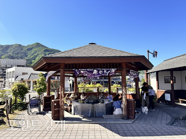 観光客が鬼怒川温泉駅前の無料足湯で休んでいる／写真＝パク・ジヌ特派員 ⓒポイント経済